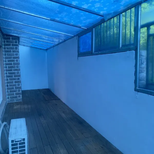 벽돌 기둥과 창, 실외기가 보이는 정리된 베란다